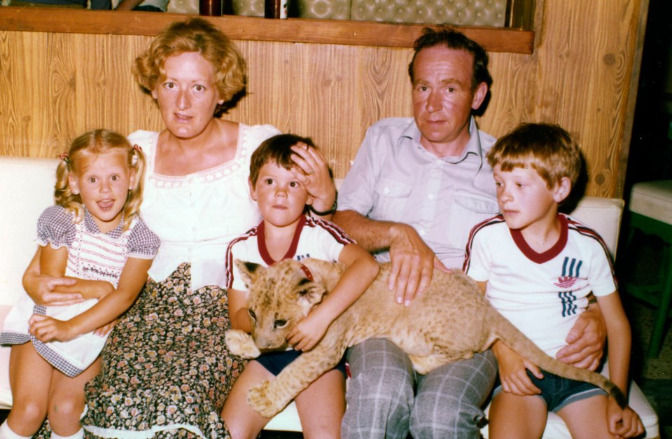 Rachel sitting with her mum, older brothers and dad Jim during a family holiday where they met a tiger cub