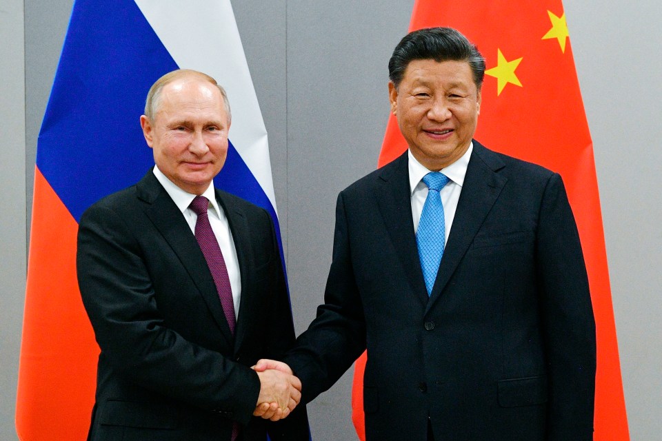 Vladimir Putin shaking hands with the Chinese president Xi Jinping