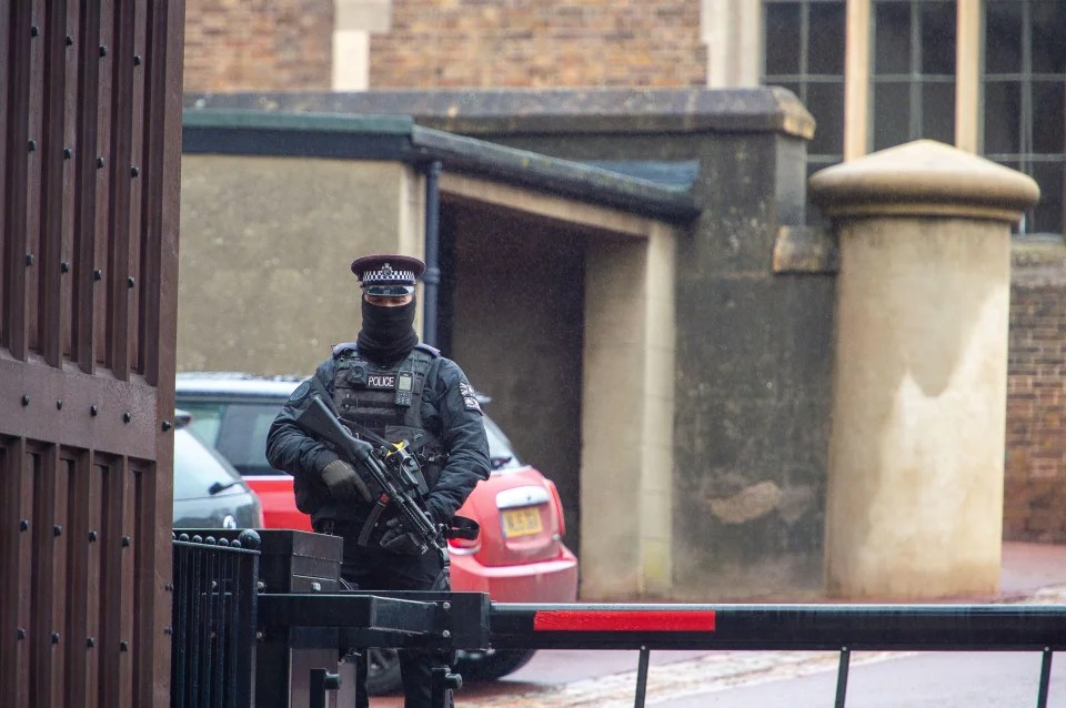 An armed police officer outside Windsor Castle while Her Majesty remains resident