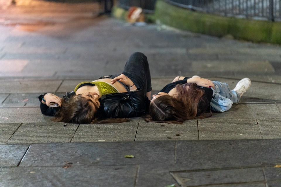 Two girls lie on the street as the UK welcomed 2022