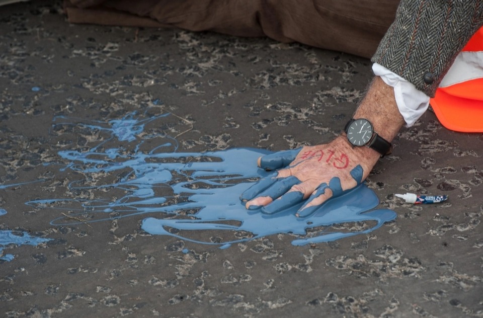 Activists glue their hands to the road to delay their removal by police in Hatfield