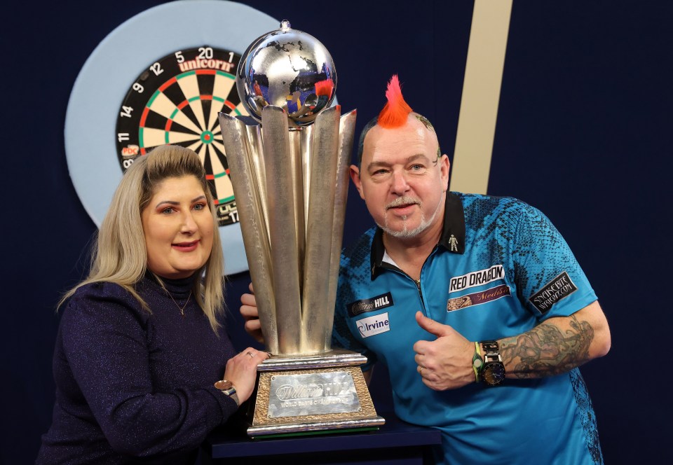 Wright celebrates with the trophy alongside wife Joanne