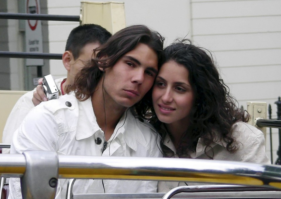 a man and a woman are sitting next to each other in front of a no parking sign