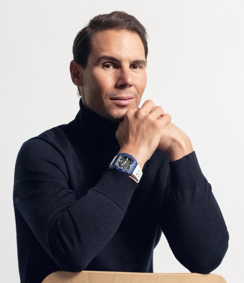 a man wearing a black turtleneck and a blue watch