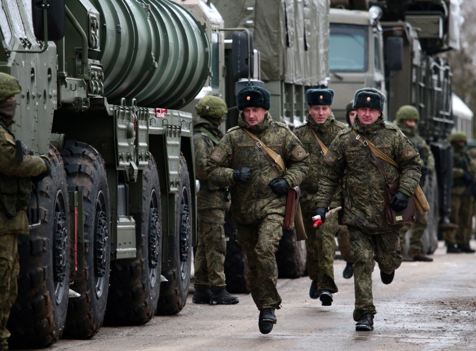 Servicemen of an S-400 Triumf missile system crew rush by as an anti-aircraft military unit of the Russian Air Force enters combat duty twelve miles away from the Ukrainian border