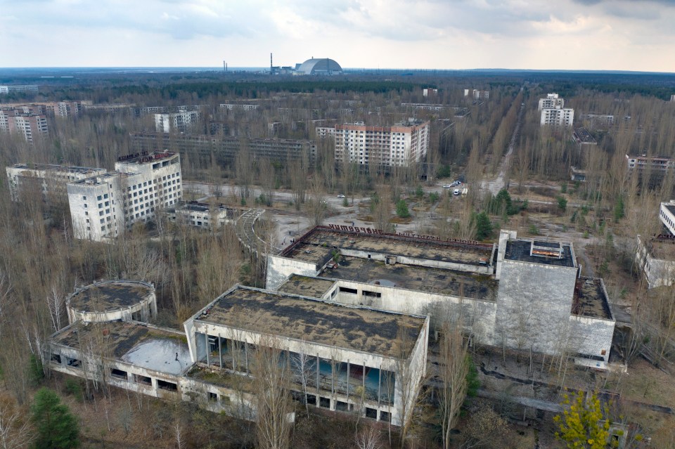 The abandoned town of Pripyat with reactor, now covered, in the background