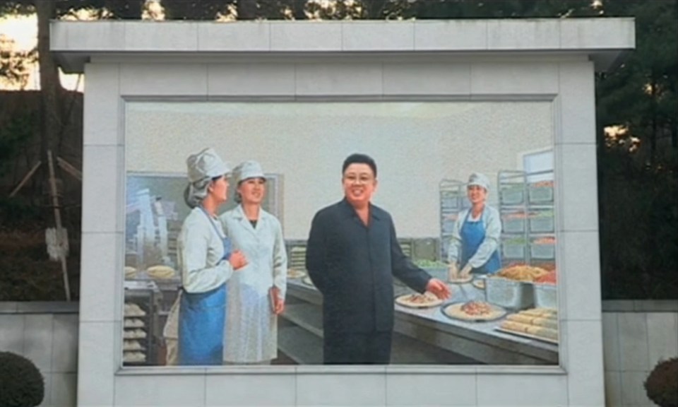 A mural shows Kim Jong-il in a kitchen where burritos are being prepared