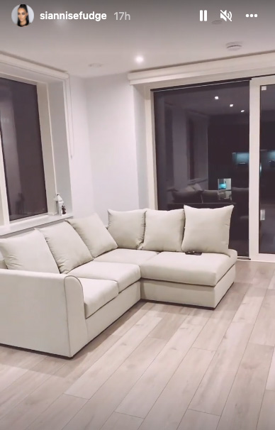 The living space boasts a white L-shaped sofa