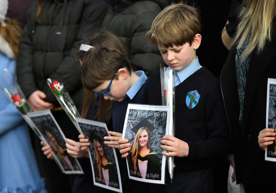 Children from her school hold photos of her in her memory