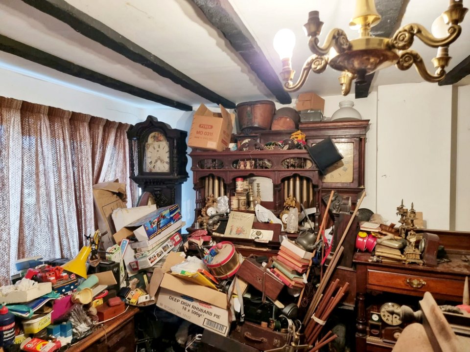 A treasure trove of antiques was found hidden beneath piles of rubbish in this hoarder's home