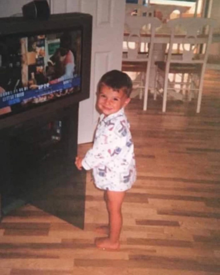 A young Mason Mount grins as he watches the telly