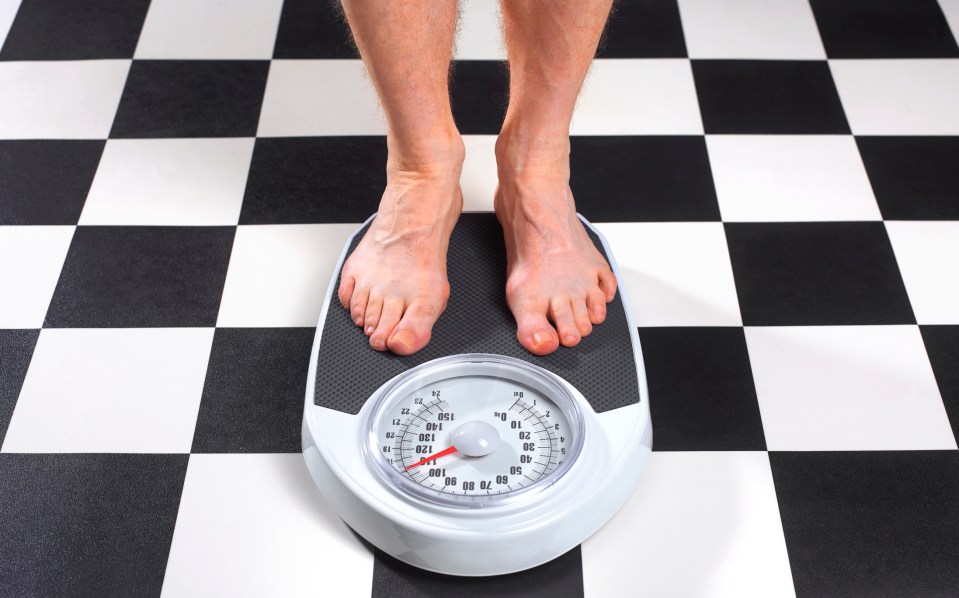 Person weighing themselves on a bathroom scale.