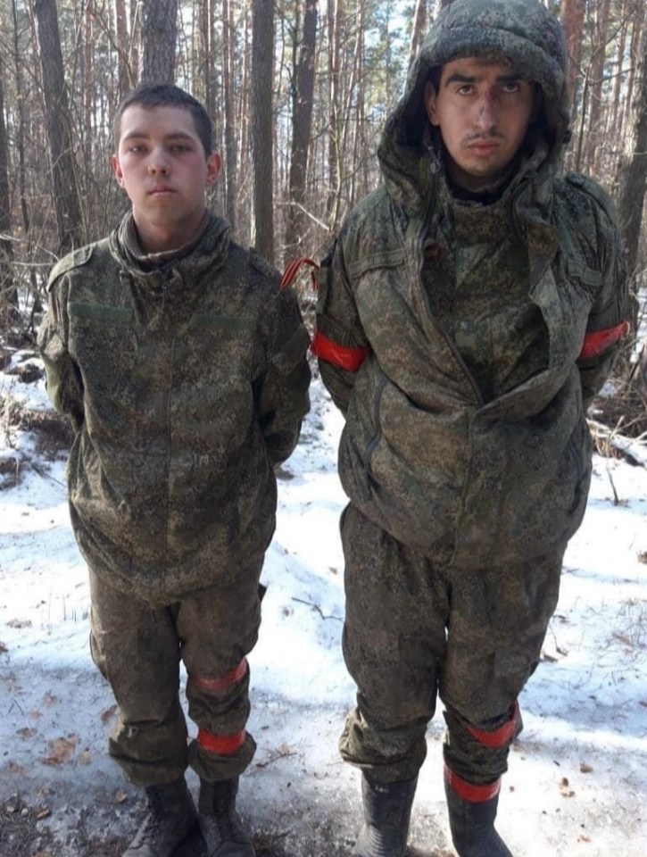 Russians soldiers with red tape around their arms and legs were captured by Ukrainian troops