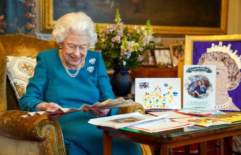 Her Majesty smiled as she studied a fan handed to Queen Victoria to mark her Golden Jubilee in 1887