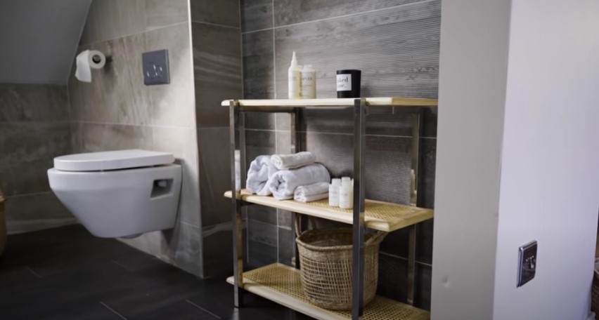 She placed a rattan style shelf in her bathroom