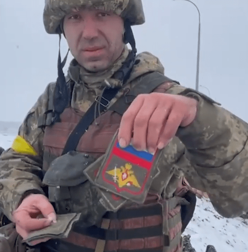 A Ukrainian soldier showed off the patches of slain Russian troops