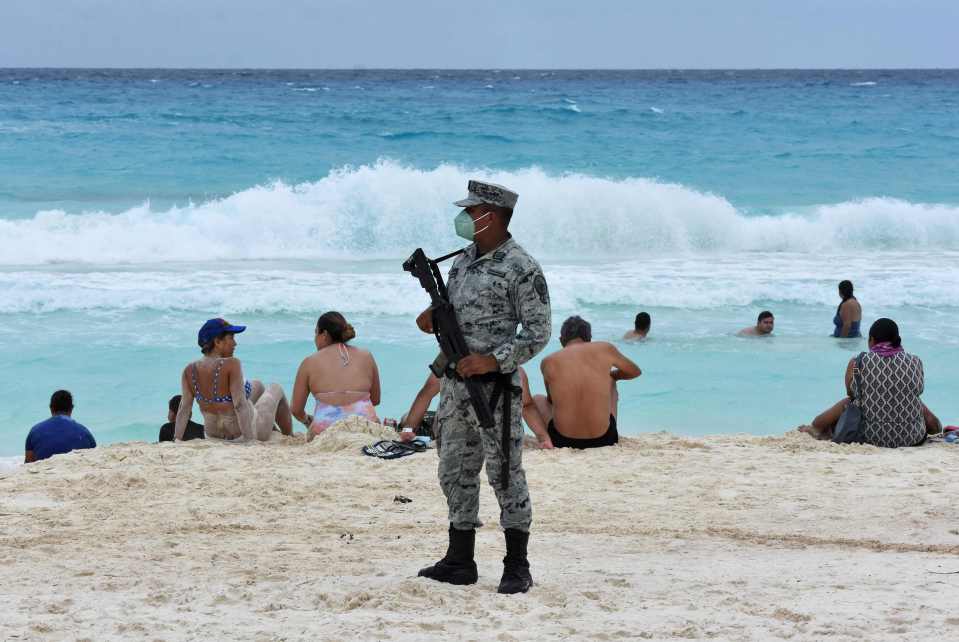 A member of the new  Tourist Security Battalion stands guard in Cancun last month