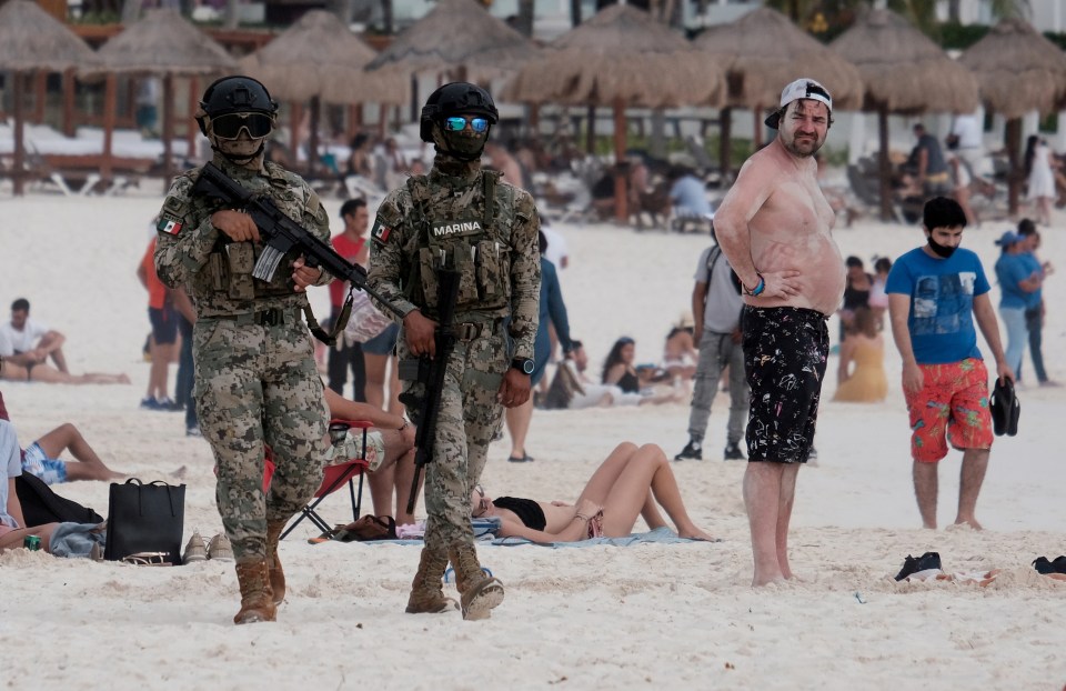 Mexican soldiers patrol a tourist beach in Cancun last month after a spate of murders