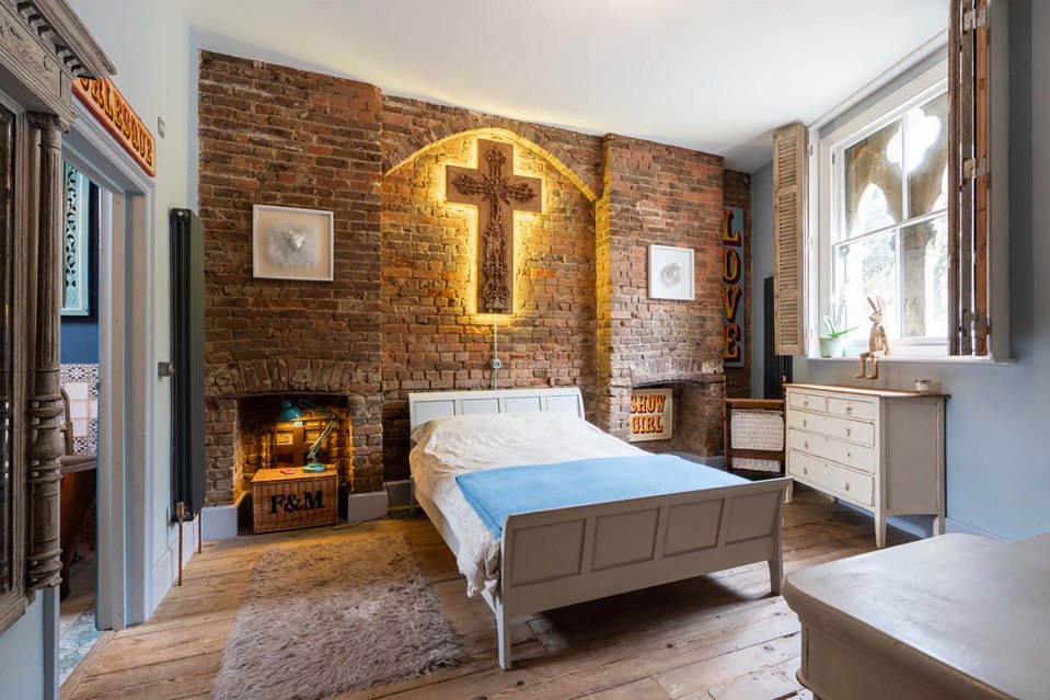 A light-up crucifix hangs over the bed