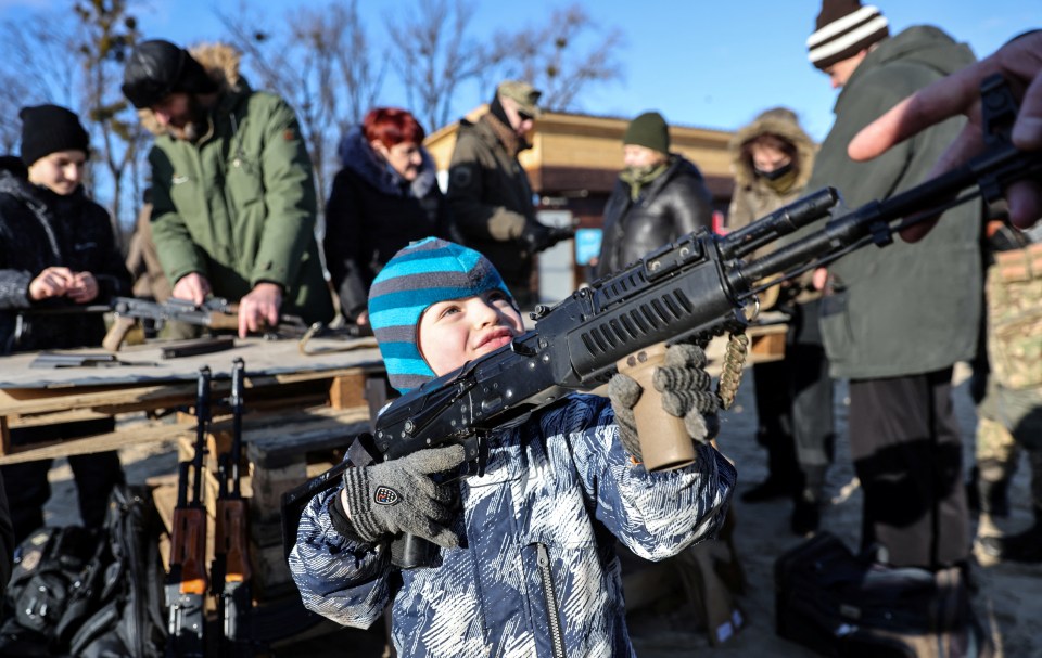 A young Ukranian boy learning how to fire a gun amid fears of invasion