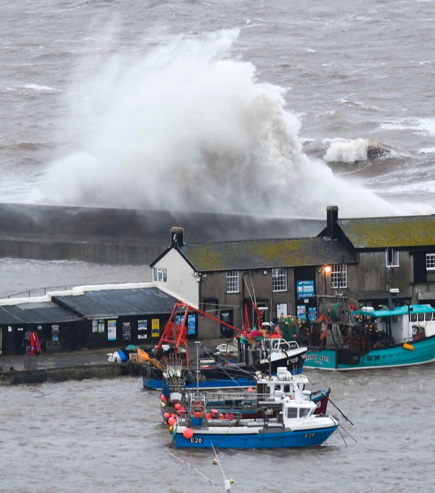 Stormy seas whipped up by gale force winds crash against the harbour wall at Lyme Regis in Dorset