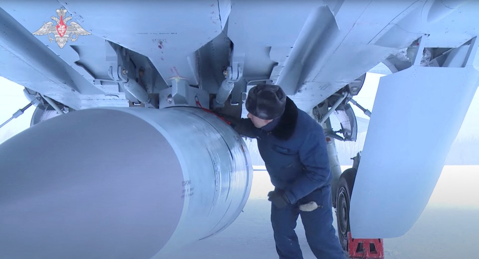 An airman checks a Russian MiG fighter jet in the region