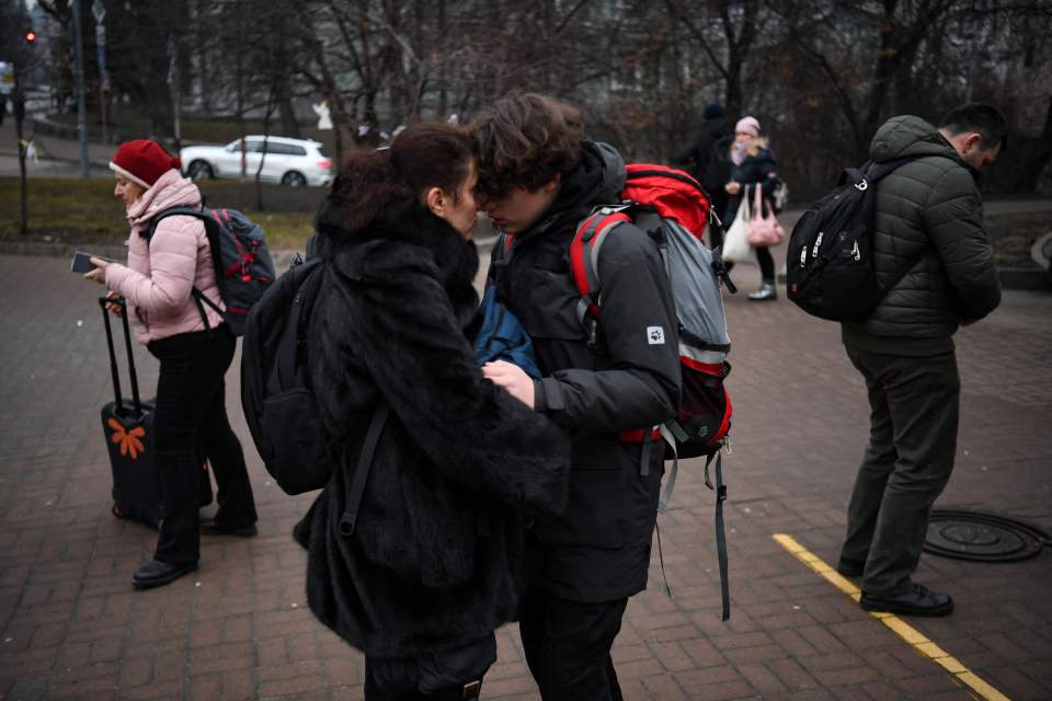 Two people embrace outside a metro station amid the exodus