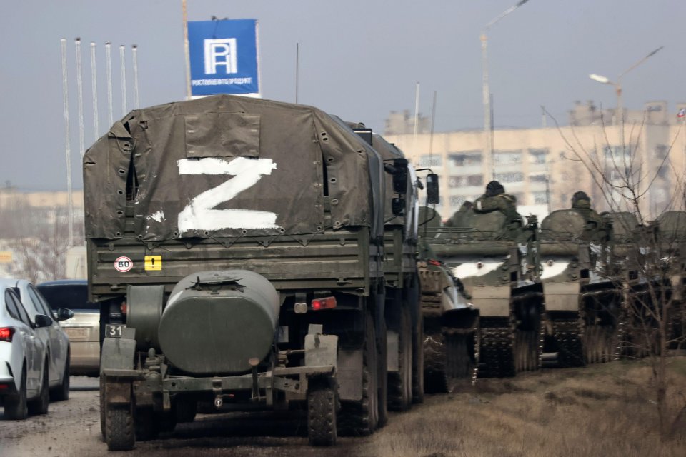 A column of army trucks moves across the town of Armyansk