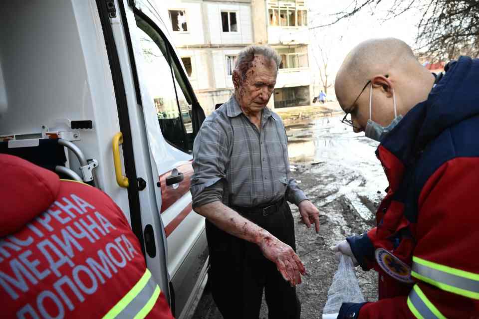 Emergency unit staff treat an injured man after bombings on the eastern Ukraine town of Chuguiv