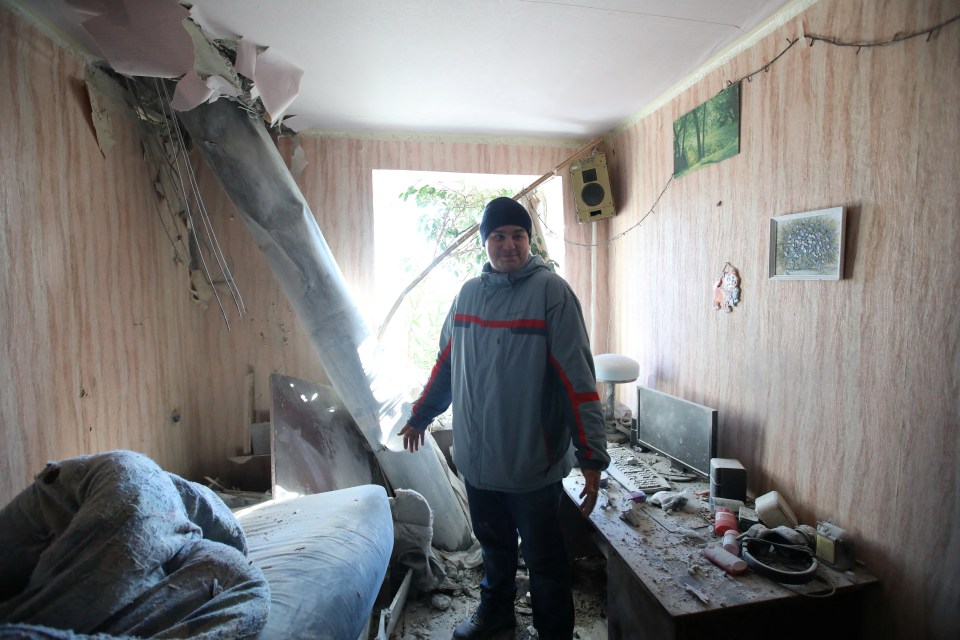 Local stands in his flat after shelling in battle for Kharkiv