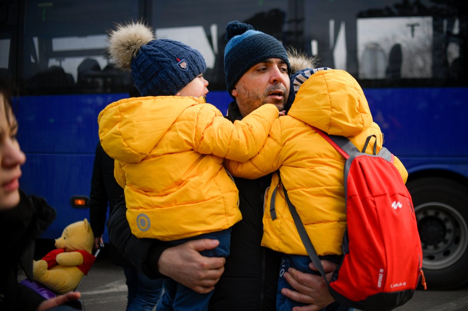 A man hugs his twin boys after they managed to escape Ukraine