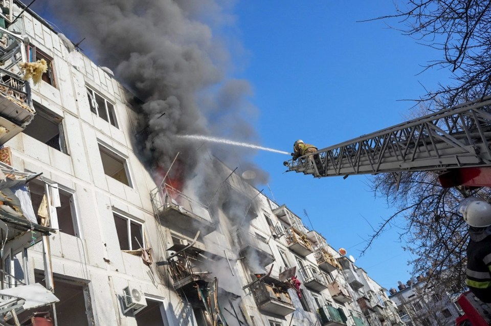 Ukrainian firefighters try to extinguish a fire after an airstrike hit an apartment complex in Chuhuiv