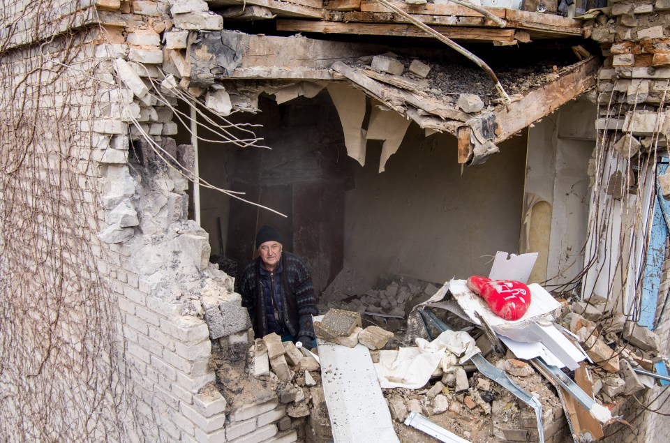 A man surveys the damage in a residential building in Mironova Street in Donetsk after a shelling attack