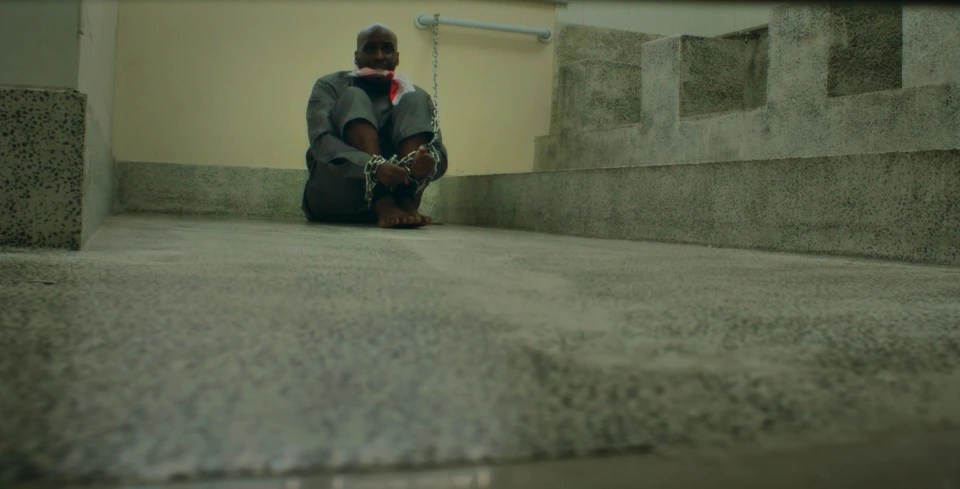 A man in chains was seen sitting in chains during one scene