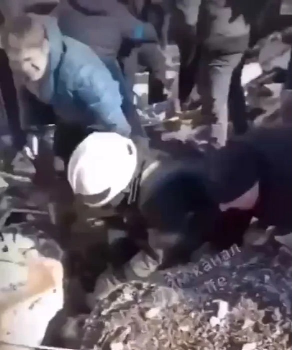 A young girl is pulled from the rubble of a bomb site