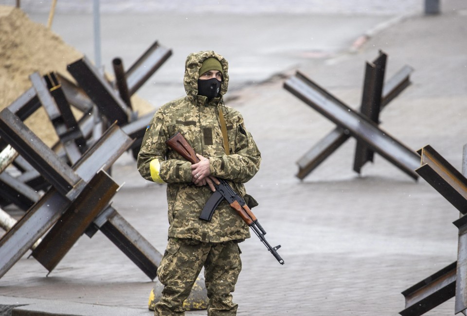 Ukrainian troops lay out tank traps as they prepare for the siege of Kyiv