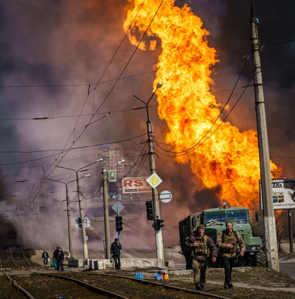 Ukrainian soldiers move away after Russia destroyed a building in the Moskovskyi district in Kharkiv