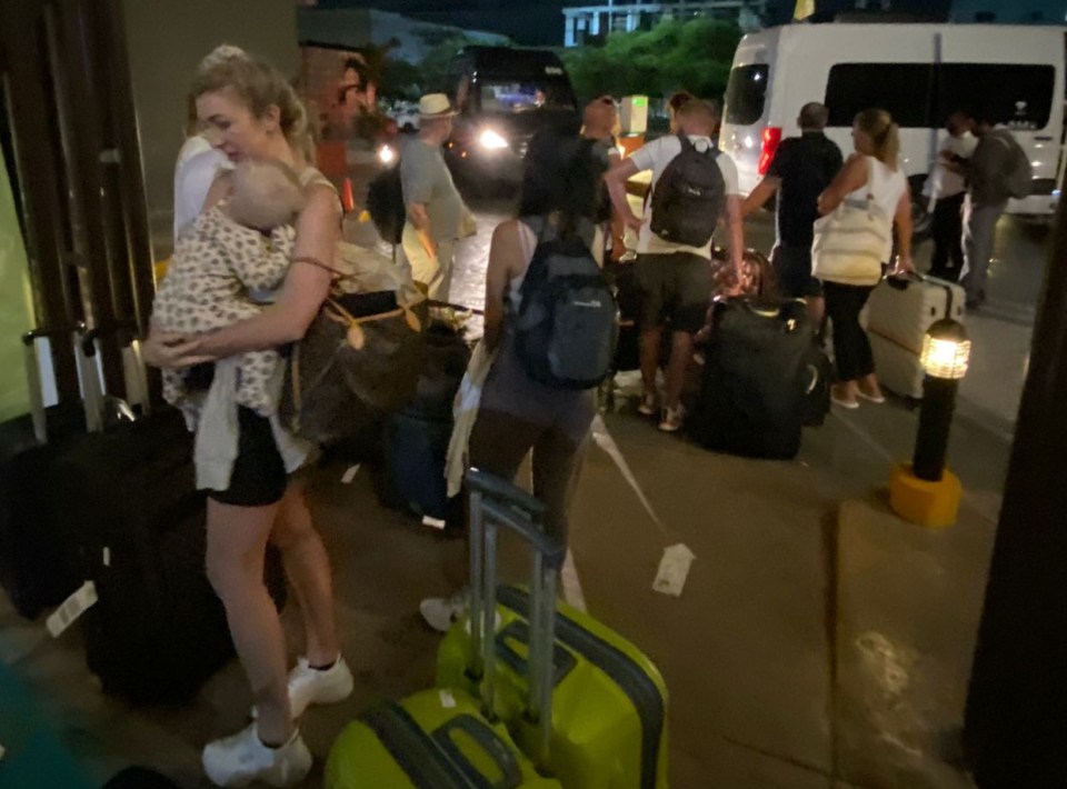 A woman was seen cradling her baby as she waited for a flight back to the UK