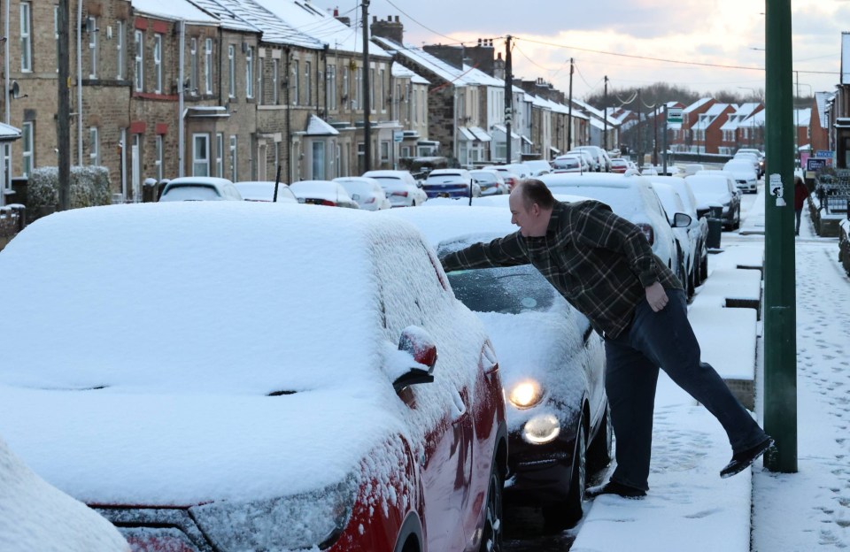 Motorists clear snow from their vehicles on a residential street in Durham this morning