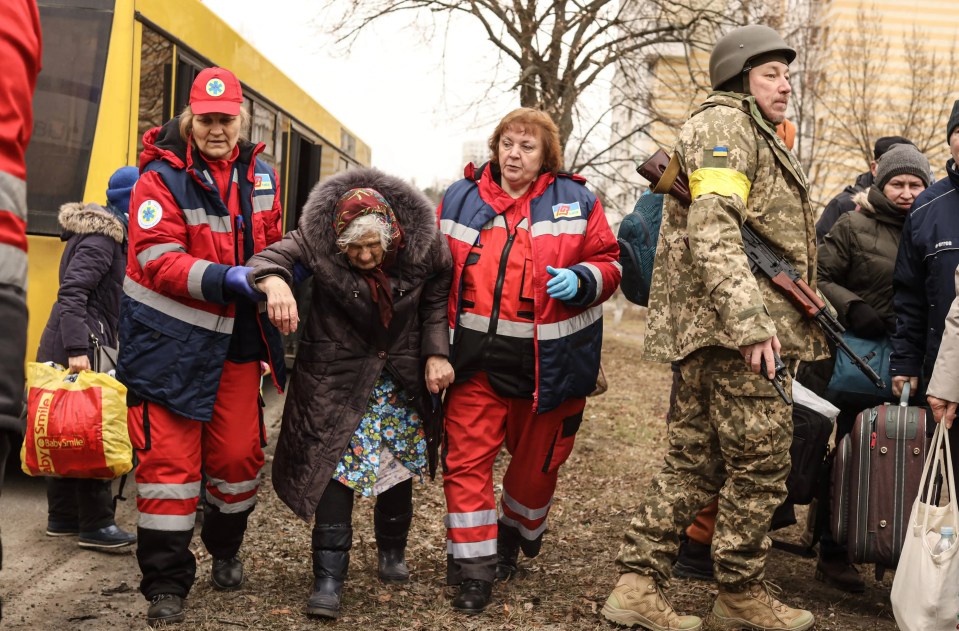 A woman is helped to safety after shelling Irpin near Kyiv