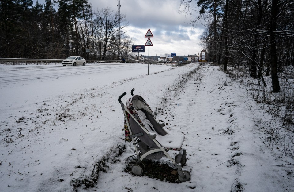 An abandoned buggy lies covered in snow in Irpin, near Kyiv