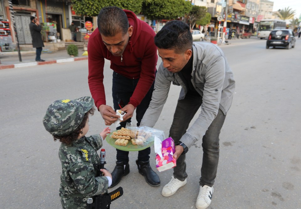 Palestinians handing out sweets in Gaza after the massacre