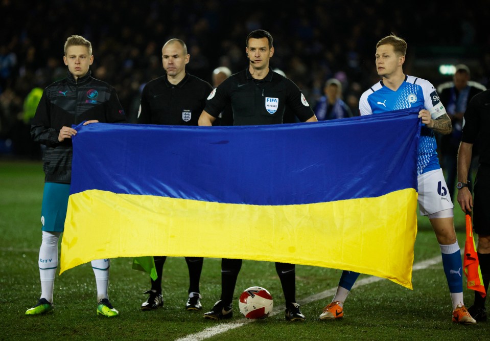 Zinchenko and Peterborough skipper Frankie Kent hold up a Ukrainian flag before kick-off