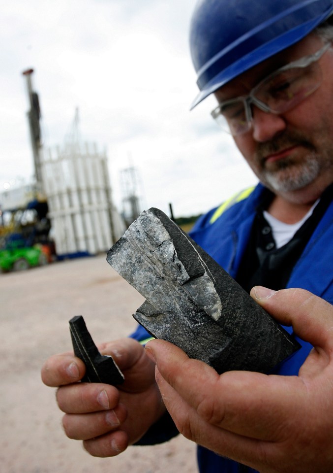 A worker holds a segment of Bowland Shale from which shale gas can be extracted