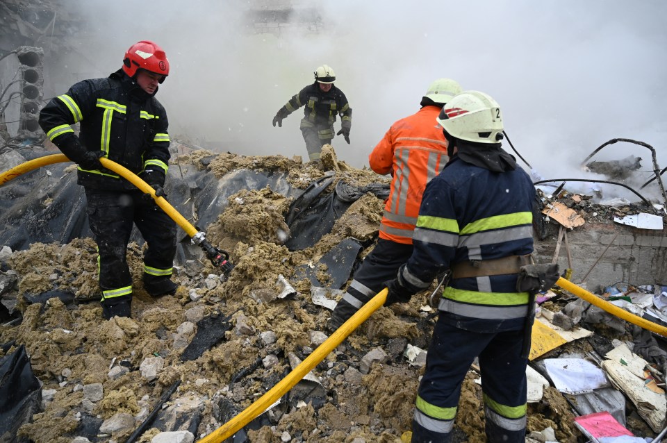 Firefighters work in the rubble of the school building after today's air strike