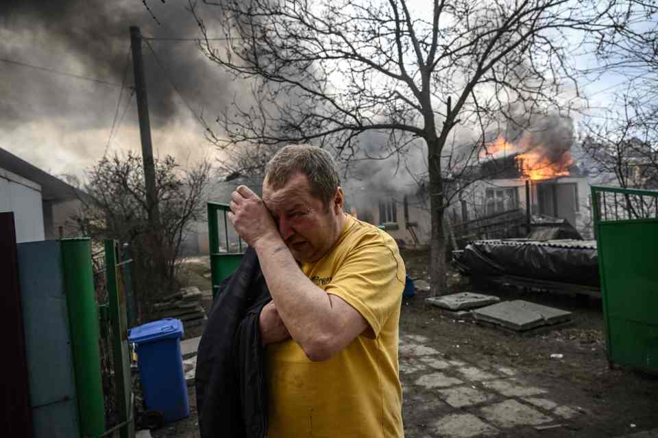 A resident weeps outside his burning home today in Irpin near Kyiv