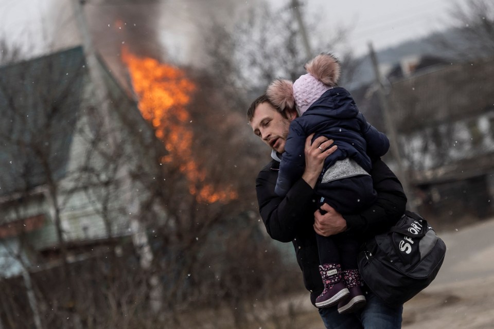 Running with a child in his arms, this man makes a desperate bid to escape Irpin