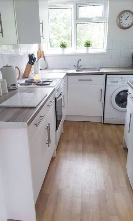 The woman started by painting the cabinets white and putting a wood vinyl on the worktops