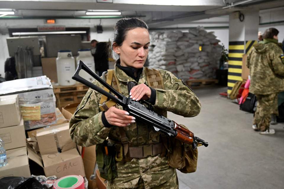 Iryna Sergeyeva, Ukraine's first female volunteer fighter, holding her Kalashnikov machine-gun