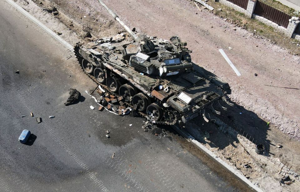 A charred Russian tank lays destroyed on the roadside in Ukraine